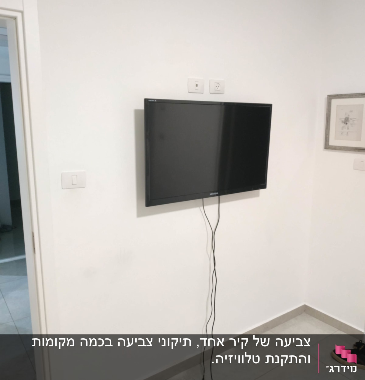 טלוויזיה תלויה על הקיר עם כבלים משתלשלים